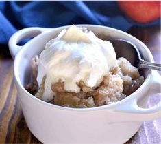 a close up of a bowl of food with ice cream and fruit in the background