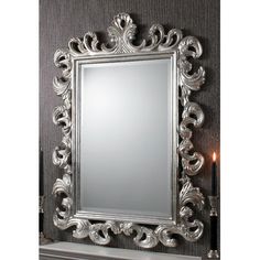 a silver mirror sitting on top of a mantle