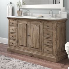 a white toilet sitting next to a wooden vanity