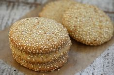 three sesame seed cookies sitting on top of a piece of wax paper