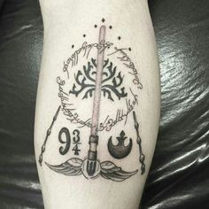 a tattoo on the leg of a person with an arrow and star wars symbols around it