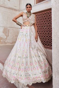 Ivory banarasi chanderi lehenga with all over woven vintage pattern, meenakari mirror embroidery and scalloped cut work hem. Paired with padded deep V neck blouse with all over floral pattern zardozi embroidery, pearl tasselled shoulder straps, shimmer tissue dupatta with circular embroidered border and meenakari mirror embroidered waist belt with geometric pattern carved motif in centre.
Components: 4
Pattern: Woven and Embroidered
Type Of Work: Vintage Pattern, Meenakari Mirror, Pearl, Bead, G Meenakari Mirror, Aditi Gupta, Chanderi Lehenga, Tissue Dupatta, Mirror Embroidery, Zardozi Embroidery, Embellished Belt, Embroidered Border, Hem Blouse