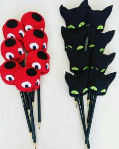 four black and red pencils with green eyes on them