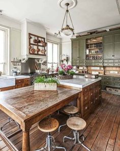 an old fashioned kitchen with wooden floors and lots of counter space, including a large center island