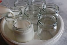 there are many glass jars with milk in them