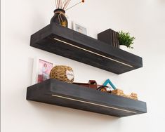 two black floating shelves with decorative items on them