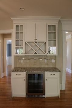 an empty kitchen with white cabinets and granite counter tops on hard wood flooring area