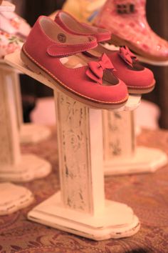 three pairs of shoes are sitting on top of each other in front of a table