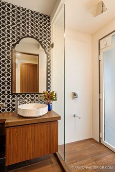 a bathroom with a sink and mirror next to a walk - in shower stall area