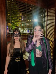 two women dressed up as batman and catwoman posing for the camera with their hands on their face