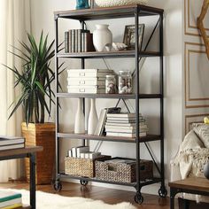 a living room filled with furniture and a book shelf next to a window on top of a hard wood floor