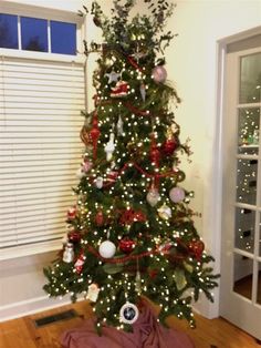 a decorated christmas tree in the corner of a room