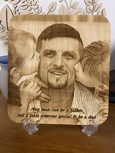 a wooden photo frame with a drawing of a man and two children on it next to a ruler