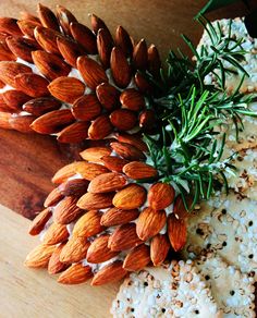 almonds and rosemary sprigs on a cutting board next to some rice flakes