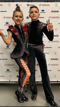 two children in costumes posing for a photo on the red carpet at an awards event