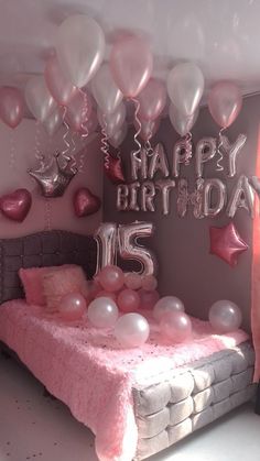 a bedroom decorated in pink and silver with balloons