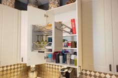 an open cabinet in the middle of a kitchen counter with spices and condiments