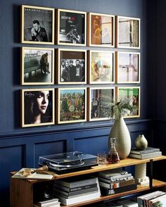 a room with blue walls and pictures on the wall, bookshelf in front of it