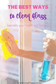 a woman is cleaning the window with a yellow cloth and blue liquid in her hand