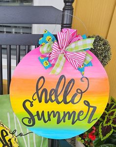 a wooden sign that says hello summer on the side of a chair next to potted plants