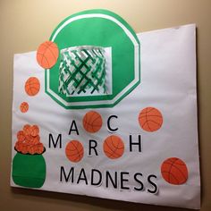 a paper sign that says march madness with basketballs and a green hat on it