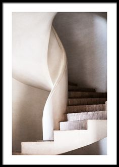 a spiral staircase with white walls and carpet