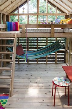 a loft bed with a hammock hanging from the ceiling