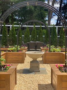 an outdoor seating area with wooden planters and plants in the center, surrounded by trees