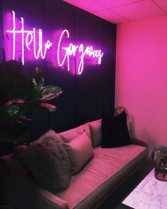 a living room filled with furniture and neon signs on the wall above it that says hello gorgeous