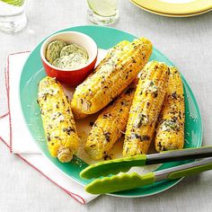 grilled corn on the cob with dipping sauces and green beans in a bowl