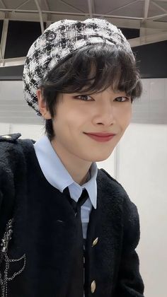 a young boy wearing a black and white hat