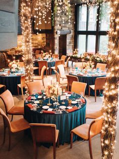 a room filled with lots of tables covered in blue cloths