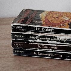 a stack of books sitting on top of a wooden table