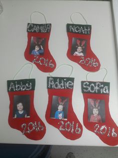 four christmas stockings with pictures hanging from them