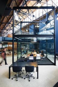 an office with glass walls and people walking around