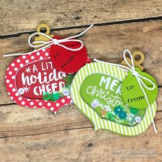 three handmade christmas ornament hanging from string on wooden planks with text