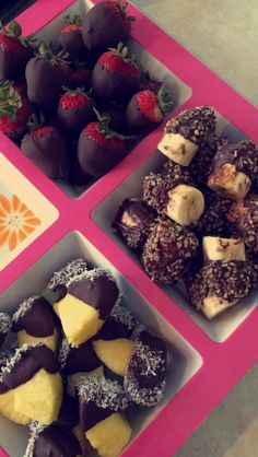 four trays filled with assorted chocolate covered strawberries and other dessert items on a table