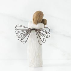 a white ceramic figurine with brown hair on it's head and hands wrapped in wire