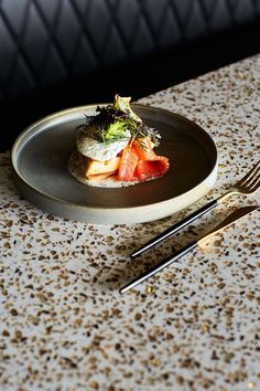 a plate with some food on it next to two forks