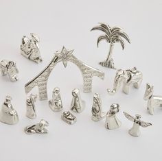 a group of silver figurines sitting on top of a white table next to each other