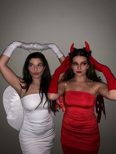 two women dressed in devil costumes posing for the camera with their hands on their head