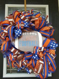 a football wreath on the front door with orange and blue ribbon around it that says florida football