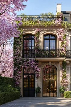 a large building with lots of windows and flowers on the outside wall, along with trees in bloom