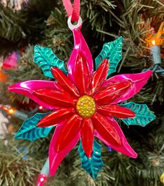 an ornament shaped like a flower hanging from a christmas tree