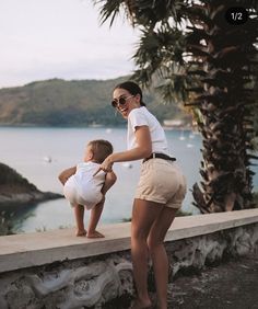 a woman and child standing on the edge of a wall