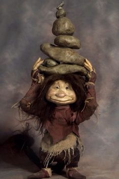 a person with a pile of rocks on top of their head in front of a gray background