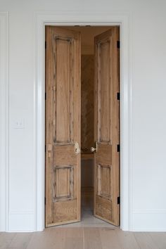 an open wooden door in a white room