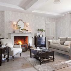 a living room filled with furniture and a fire place in the middle of the room