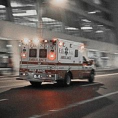 an ambulance driving down the road at night