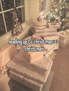 a stack of presents sitting next to a christmas tree with the words leading up to christmas > >